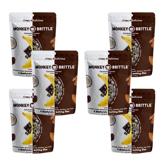 6 packs of coconut cacao flavor monkey brittle in white and brown resealable bags. On the center of the bag there is an organic banana and cacao nibs. Around the edges of the bag there is a coconut, almond, and raisin 